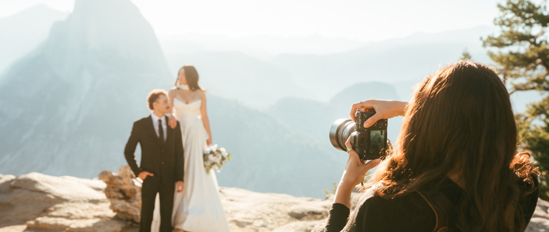 Fotógrafa fotografando um casal de noivos na montanha